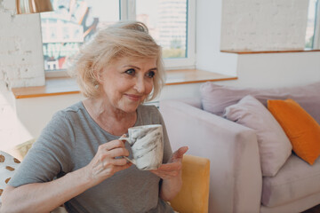 Elderly caucasian old aged woman enjoying afternoon tea at home