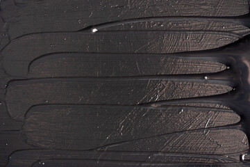 chorro de pintura fresca sobre base de madera negra con textura horizontal