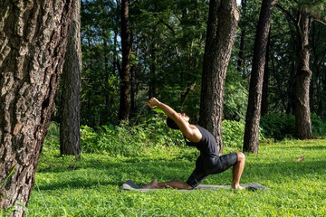 young man, doing yoga or reiki, in the forest very green vegetation, in mexico, guadalajara, bosque colomos, hispanic,