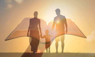 Family worship concept.Silhouette of family walking together and hand holding bible. 