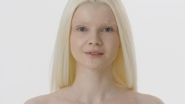 Beauty Woman face Portrait. Beautiful Spa model Girl with Perfect Fresh Clean Skin. Albino Female with Blonde hair looking at camera and smiling. Youth and Skin Care Concept. Isolated on a white