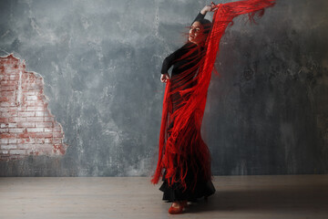 Young adult spanish woman dancing flamenco on grey vintage studio background - obrazy, fototapety, plakaty