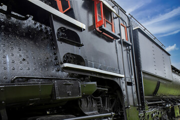 Exterior view of steam locomotive cab and tender, sunny skies, nobody