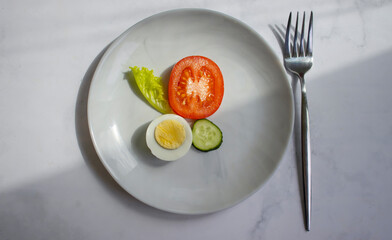 Boiled egg, tomato, lettuce on a diet plate