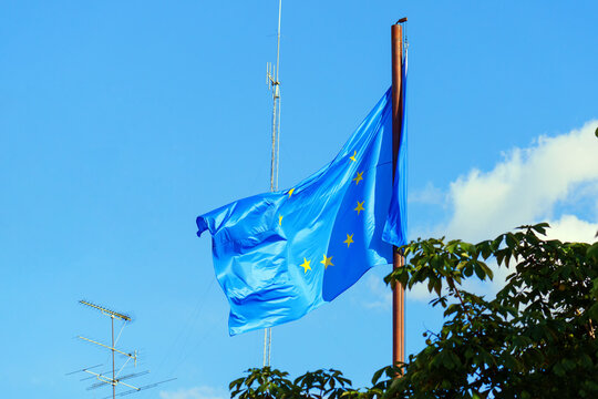 The flag of the European Union on a mast surrounded by anten