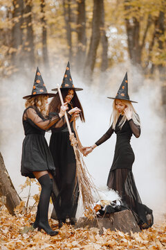Three witches in forest on Halloween dance to make magic potion