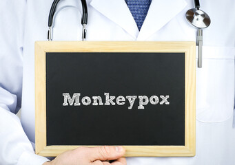 Doctor holding chalkboard with Monkeypox message