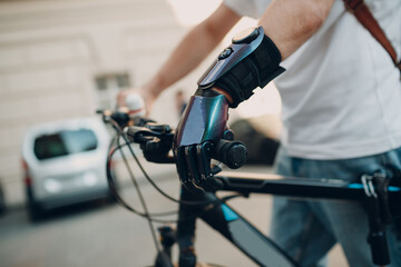 Young disabled man with artificial prosthetic hand in casual clothes riding bike