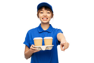 service and job concept - happy smiling delivery woman in blue uniform with takeaway hot drinks in disposable coffee cups over white background