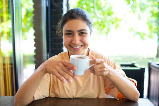 Smiling Lovely Young Indian Woman Drinking Coffee At Outside Cafe