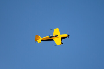 Fototapeta na wymiar Yellow training propeller airplane flies over the sea