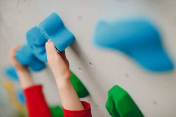 Kid child hands close up at climbing wall. Children sport, healthy lifestyle in kindergarten or sport center in school.