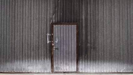 Papier Peint photo Lavable Vieux bâtiments abandonnés worn dark metal door of industrial factory building