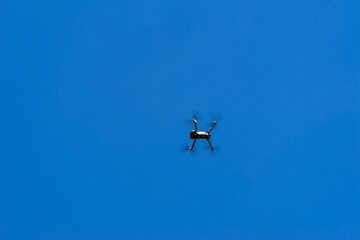 Latający dron ( kwadrokopter , Quadrocopter ) z kamerą na tle błękitnego nieba . - obrazy, fototapety, plakaty
