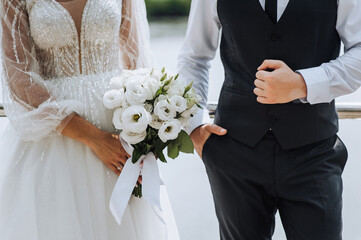 Wedding photography of the newlyweds, close-up portrait of the bride and groom with a bouquet of...