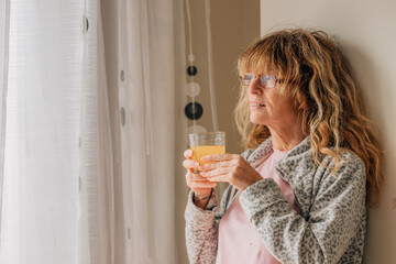 middle-aged woman at home drinking orange juice