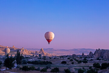 balloon over the hills in the mountains illuminated by the rays of the sun at dawn in the vicinity of Cappadocia View from above