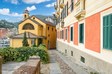 Fototapeta na wymiar Narrow street between colorful buildings at the port of Santa Margherita, Ligure, Italy.