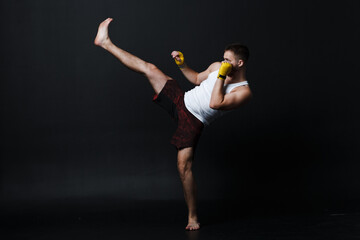 Sportsman muay thai man boxer stance at black background.