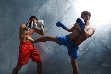Two men boxers fighting muay thai boxing.