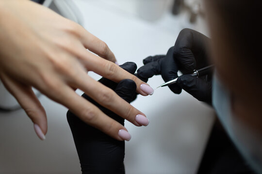 Manicure process female hands finger nails polish.