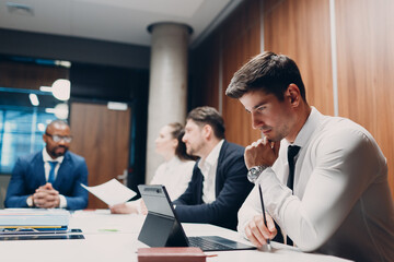 Businessman using working with laptop sits at table at office meeting. Business people man and woman group conference discussion