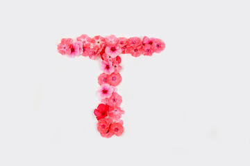 A letter T made from real fresh flowers. Creative floral font concept. Unique collection of letters and numbers for design. Spring, summer, autumn and valentines, creative idea