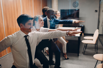 Businessman and businesswoman team doing warm up and yoga exercises before office meeting. Business healthy successful people group man and woman after conference discussion with boss.