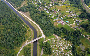 Fototapeta premium Aerial view of the big blue river with fields and forests