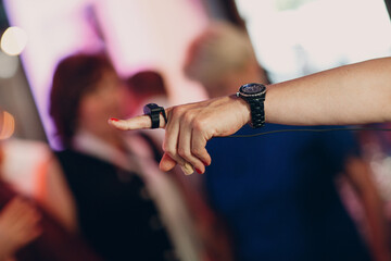 hand of the organizer or entertainer close up with a microphone on his finger and clock watch on his wrist.