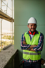 Obraz premium Portrait of men in 40s, construction worker. He is standing in construction and posing for camera.