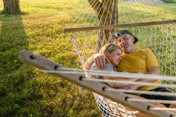 Marine veteran spends time with his wife in a hammock at sunset.