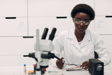 Scientist african american woman working in laboratory with soldering iron. Research and...