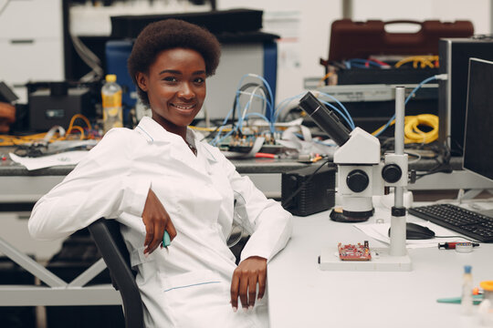 Scientist African American Woman Working In Laboratory With Electronic Tech Instruments And Microscope. Research And Development Of Electronic Devices By Color Black Woman.