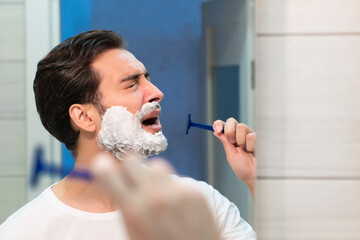 Funny man singing in the bathroom while shaving