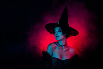Photo of charming lady magician on theme carnival fest wear witchery costume isolated on fog dark...