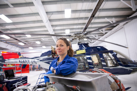 Portrait Of Confident Female Helicopter Mechanic Airplane Hangar