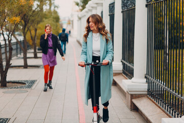 Young woman with electric scooter at the city. © primipil