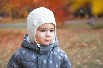 Close up portrait of cute little baby girl on autumn orange background.