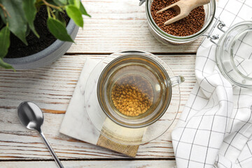 Freshly made buckwheat tea on white wooden table, flat lay