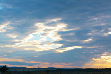 Picturesque view of beautiful countryside and cloudy sky at sunset