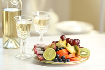 Delicious exotic fruits and wine on white table