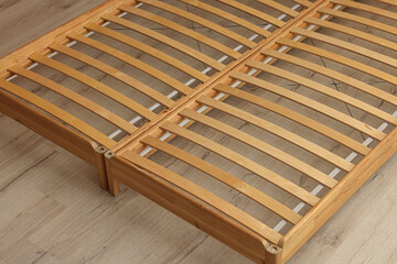 Wooden bed frame on floor, closeup view