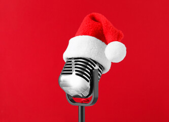 Retro microphone with Santa hat on red background. Christmas music
