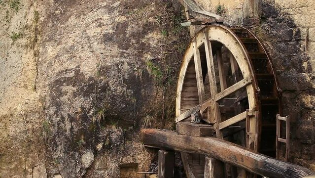 Looped rotation of the old mill's wheel on the waterfall. Veneto region, Italy