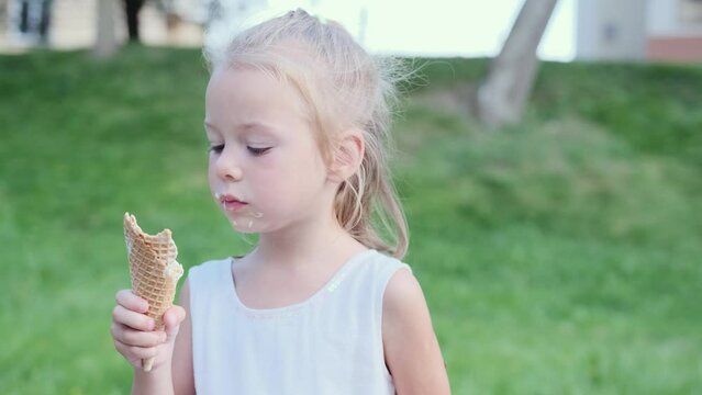 a child eats ice cream on the street in the park