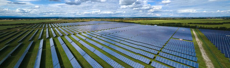 Aerial view of large sustainable electrical power plant with rows of solar photovoltaic panels for...