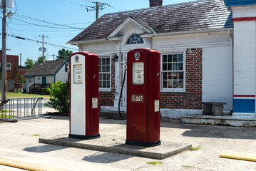 Vintage red gasoline pumps outside of an old gas station .