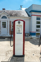 Vintage red gasoline pumps outside of an old gas station .