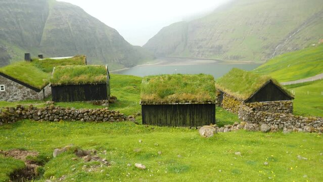 Old faroese houses in the middle of nature. Typical old house in Faroe Islands with a Grass rooftop. Grass covered house. Faroese mist nature with a lonely houses. High quality 4k footage. 
